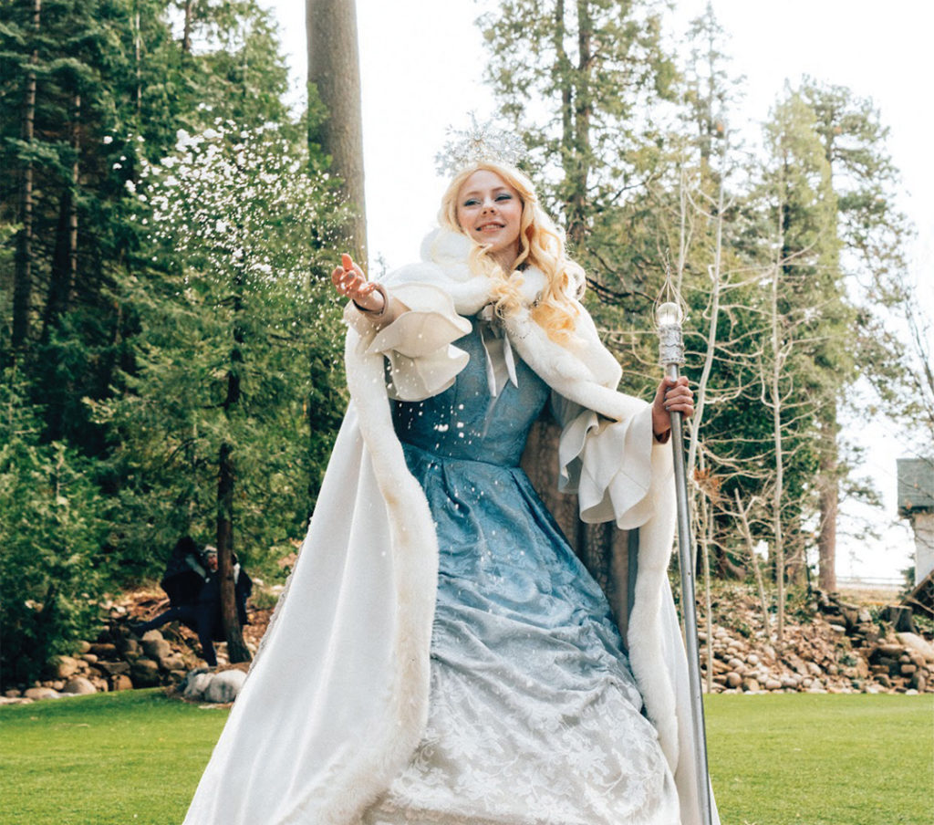 Princess Snowfall tosses a handful of snow into the air.